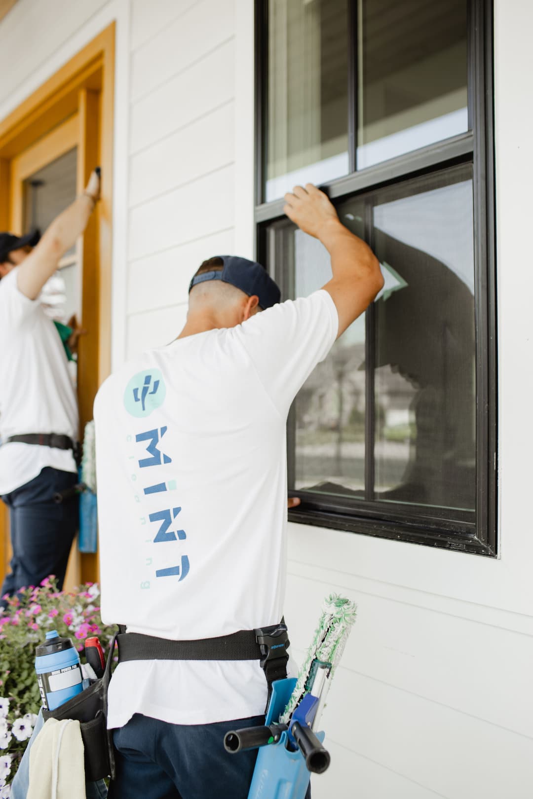 Window cleaning professional using a squeegee on a residential window. Clean home services.