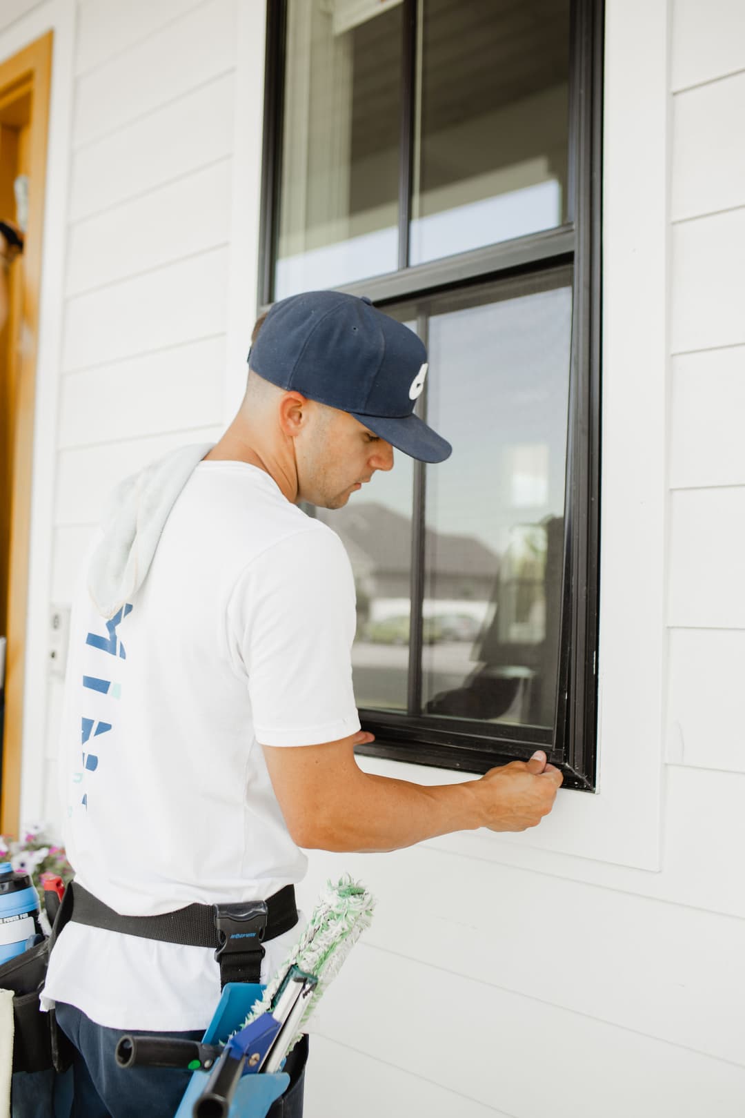 Professional window cleaner applying finishing touches on a residential window.